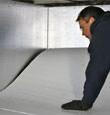 contractor installing TerraBlock™ floor insulation in a Huntington Beach crawl space